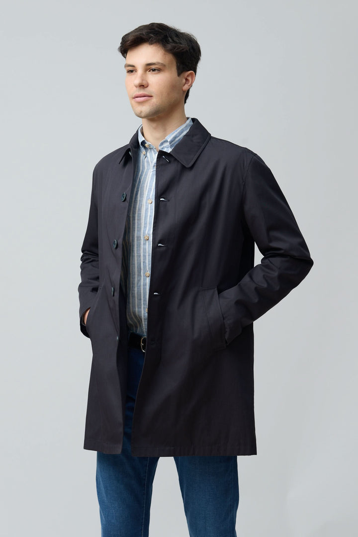 Homme portant un impermeable en gabardine de coton au design élégant et intemporel, coupe droite et col chemise.