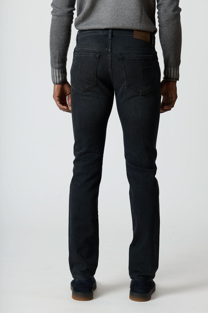 Homme portant un Jean 5 poches en denim stretch gris foncé, coupe ajustée vue de dos, style moderne avec confort durable.