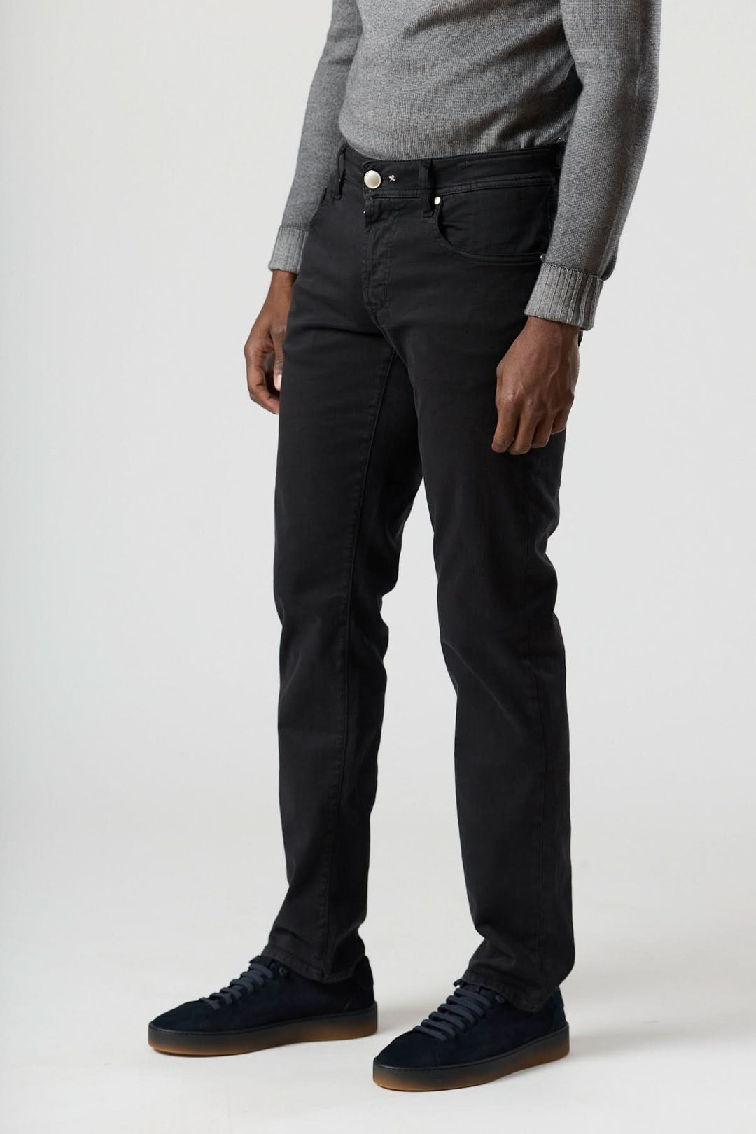 Jean 5 poches stretch coupe moderne noir avec coupe fuselée et tissu stretch, idéal pour un look urbain avec chemise blanche et sneakers.