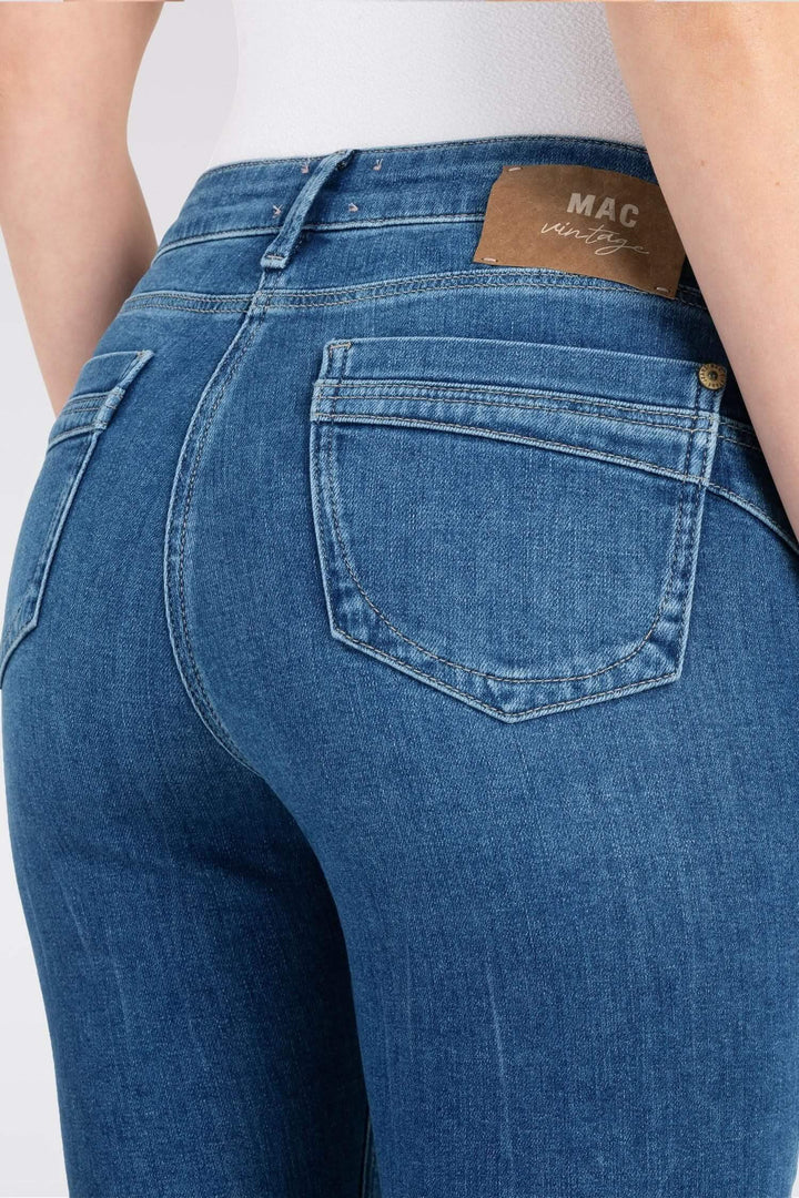 Jean slim en denim bleu avec poches arrondies et taille basse, offrant une silhouette flatteuse.