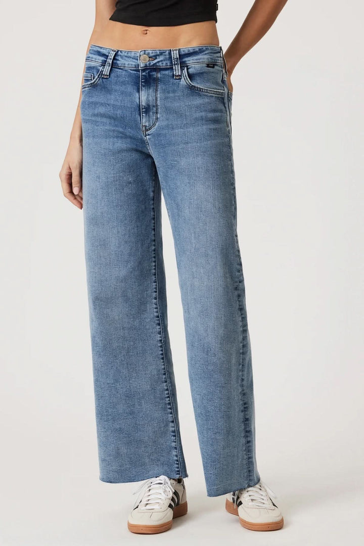 Jean Paloma jambe large taille régulière en denim bleu, offrant confort et style moderne, avec fermeture à bouton et passants pour ceinture.