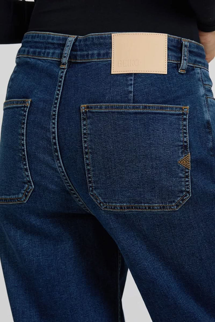 Jean Violett coupe droite à taille mi-haute, poches arrière élégantes et style polyvalent.