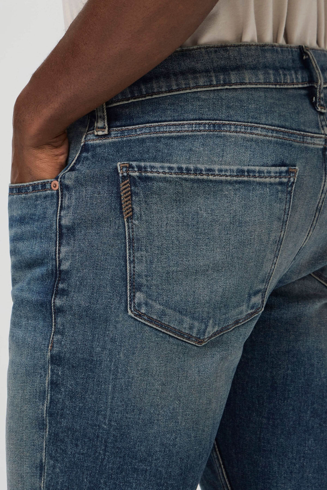 Jean ajusté slim fit avec délavé vintage et détails en cuivre, offrant confort et style.