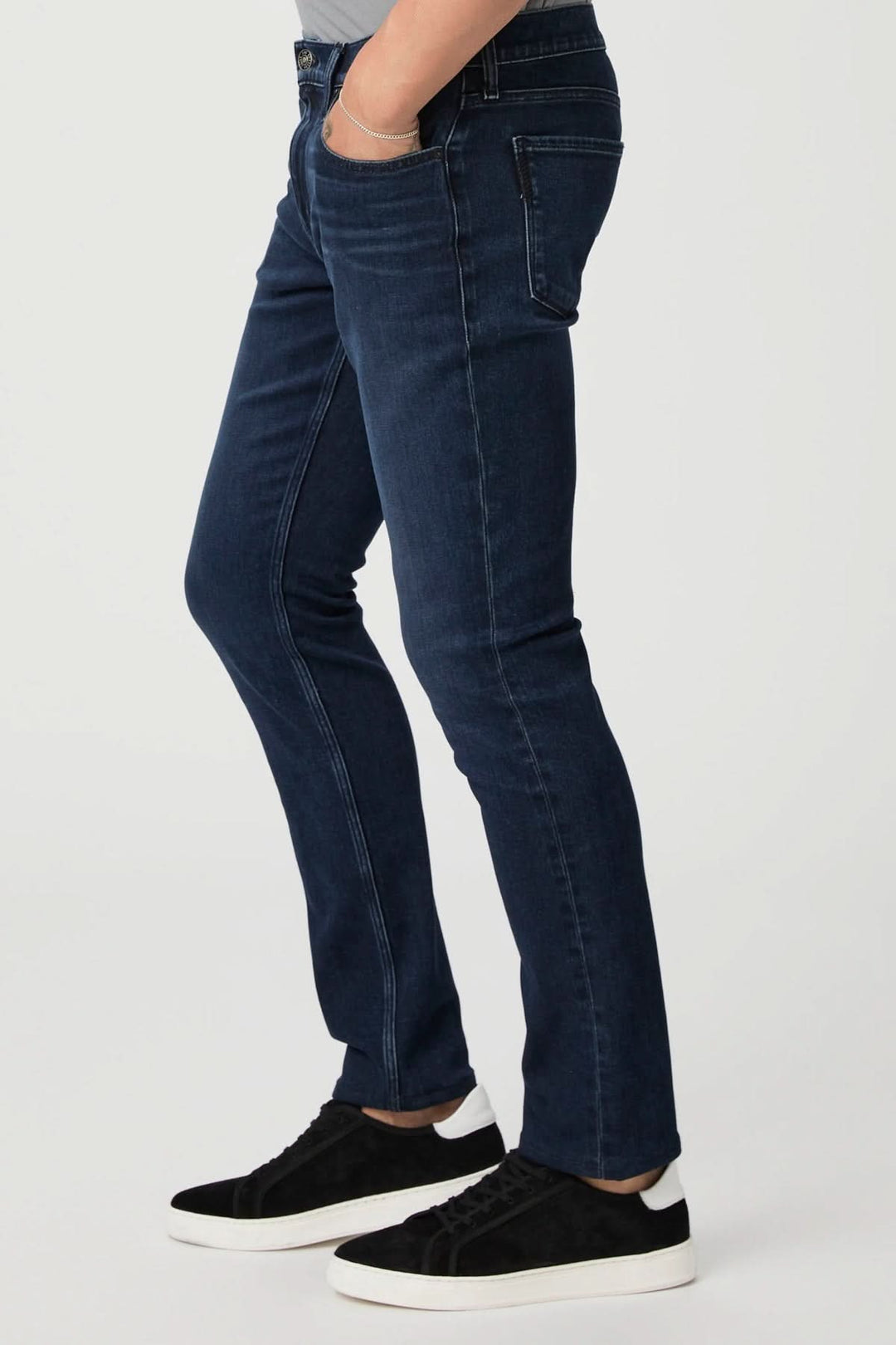 Jean ajusté vintage avec délavage foncé, porté avec des sneakers noires, style intemporel et polyvalent.