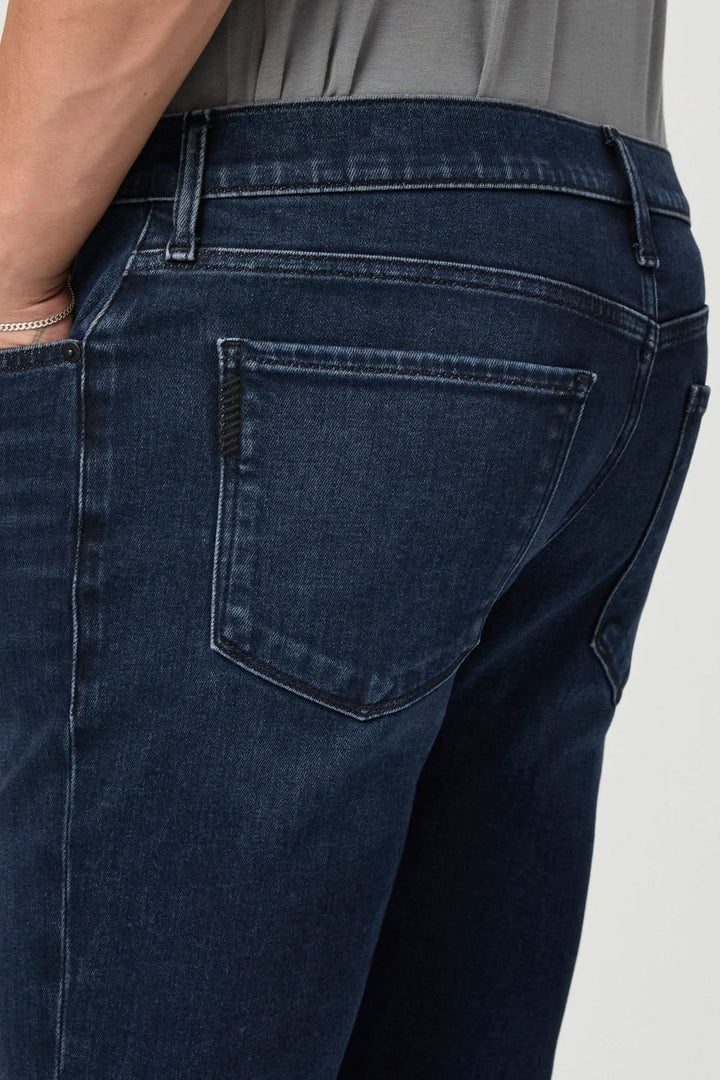 Jean ajusté vintage en denim foncé, présentant une coupe classique et des détails de délavage.
