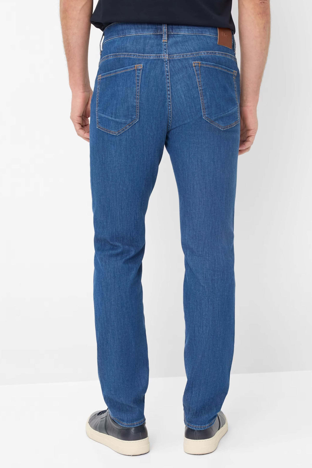 Jean cinq poches en denim bleu, coupe moderne, vue arrière avec détails de poches.