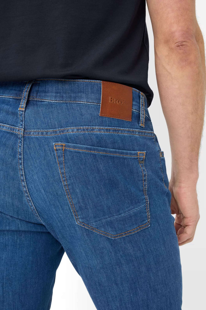 Jean cinq poches en denim bleu, vue arrière mettant en valeur la taille et la coupe moderne.