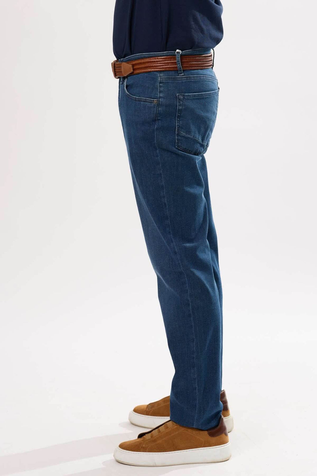 Jean classique pour homme, coupe droite, en denim extensible, porté avec ceinture et chaussures décontractées.