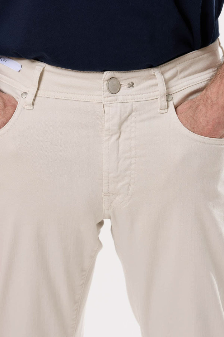 Jean coupe ajustée beige avec poches classiques et fermeture à glissière, idéal pour un style moderne et confortable.