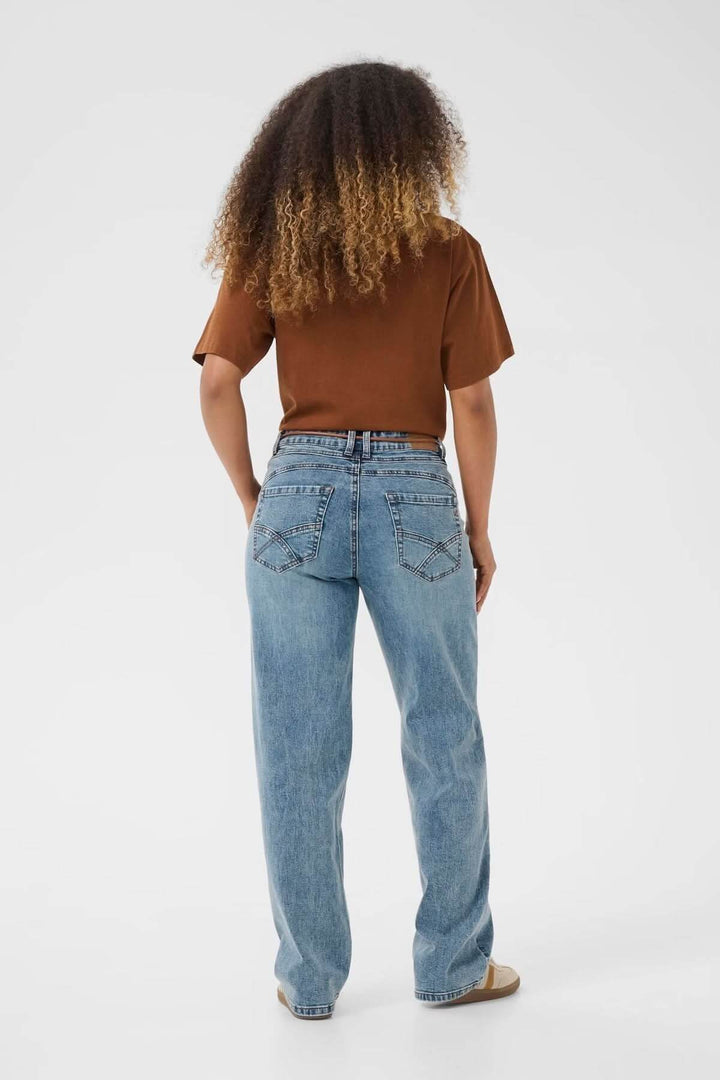 Femme portant un jean à coupe droite décontractée, vue arrière, avec un t-shirt marron.