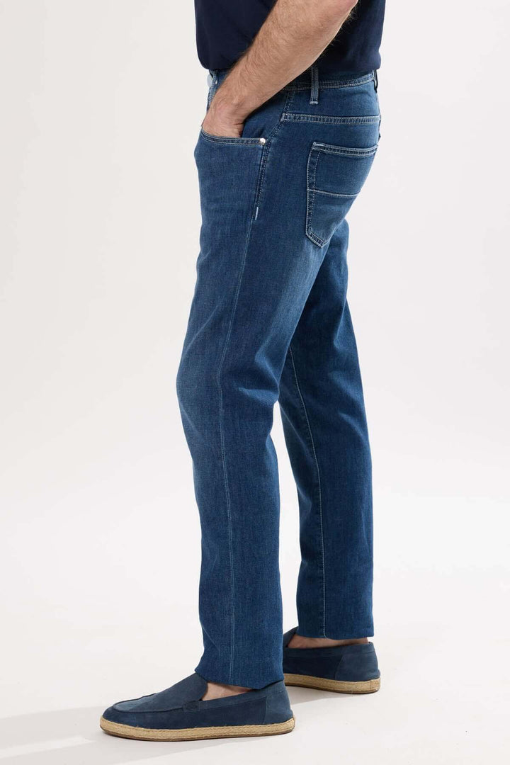 Jean coupe droite en toile extensible, finition délavée, porté avec des chaussures décontractées.