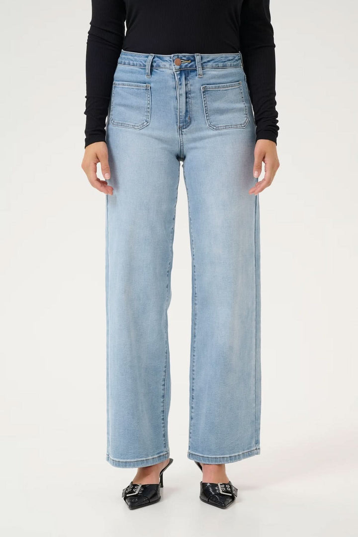 Jean à coupe large en denim bleu, taille haute avec grandes poches, style vintage modernisé.