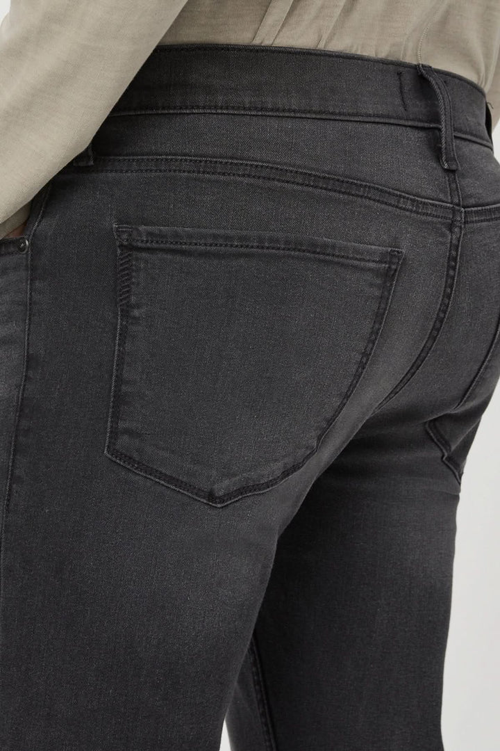 Détail du dos d'un jean slim en denim gris-noir délavé, mettant en avant la coupe ajustée.