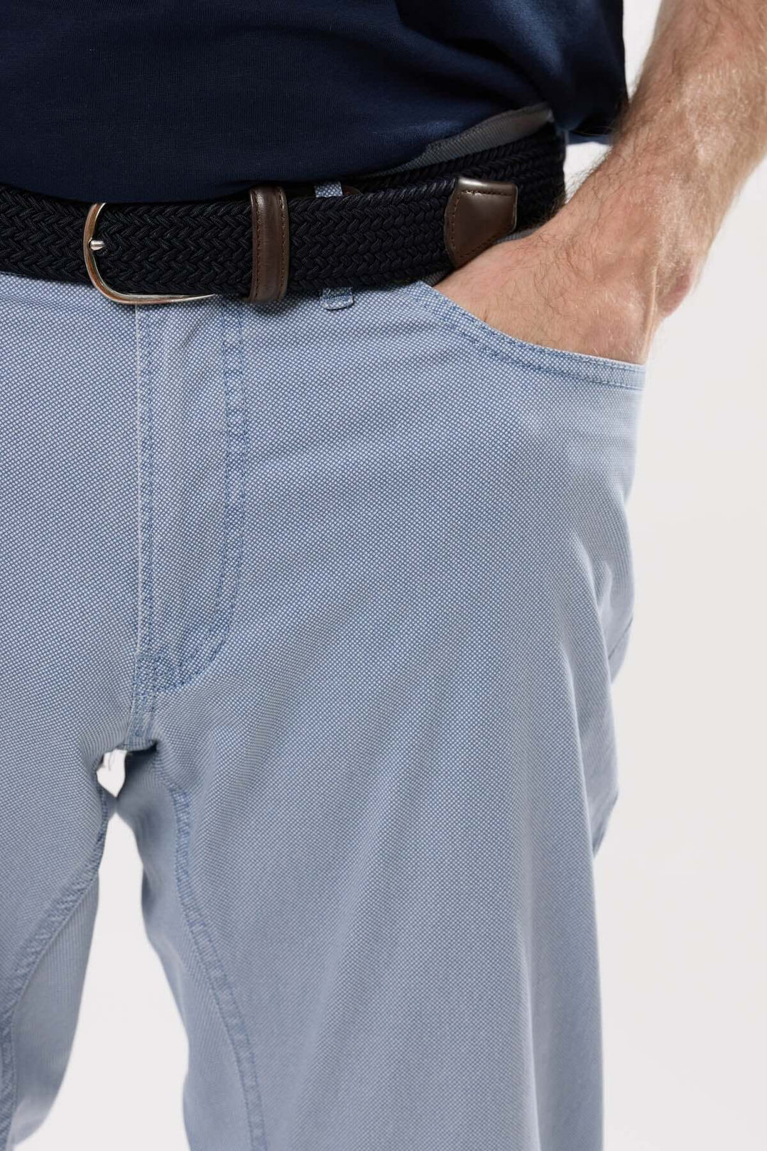Gros plan sur un jean léger à coupe droite avec une ceinture tressée, parfait pour un look décontracté et élégant.