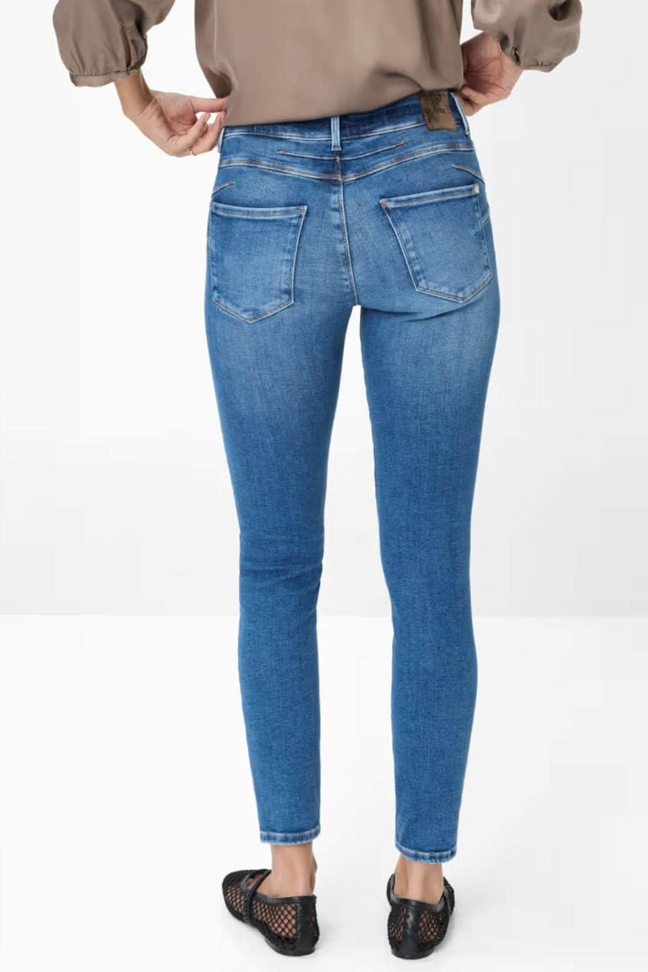 Jean skinny de style Ana ajusté en denim bleu clair, taille mi-haute, arrière avec coutures flatteuses et poches.