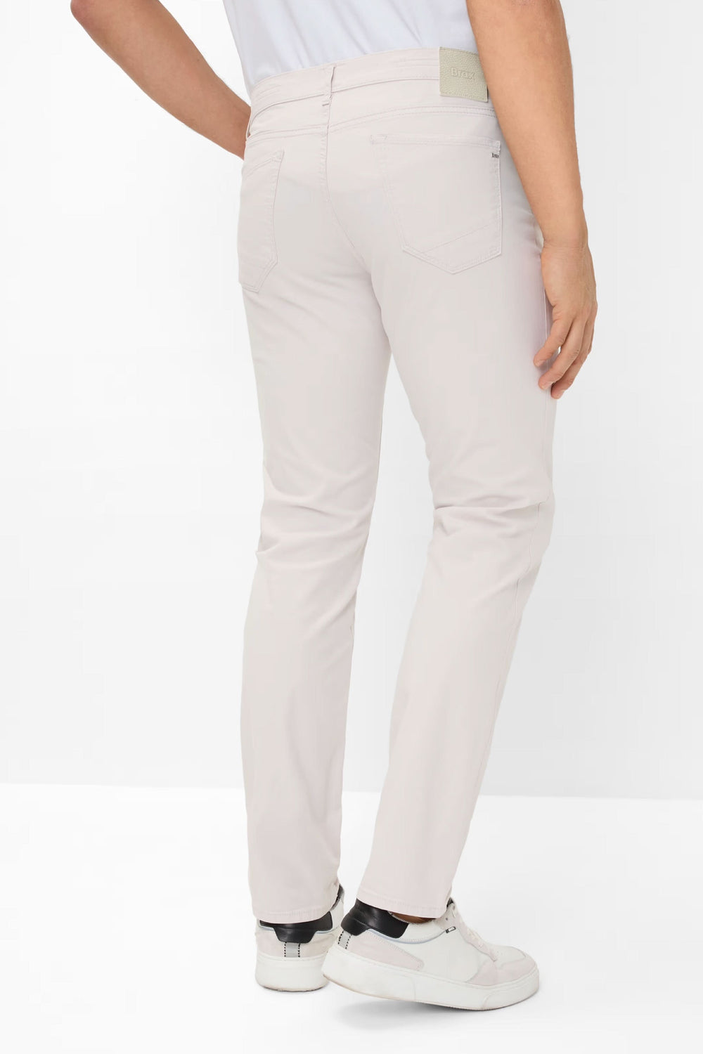 Jean style chuck léger, coupe moderne, confortable et élégant, vue arrière sur pantalon beige.