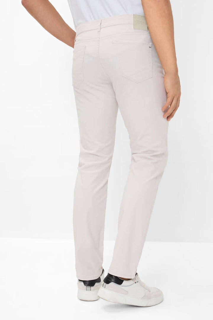 Jean style chuck léger, coupe moderne, confortable et élégant, vue arrière sur pantalon beige.