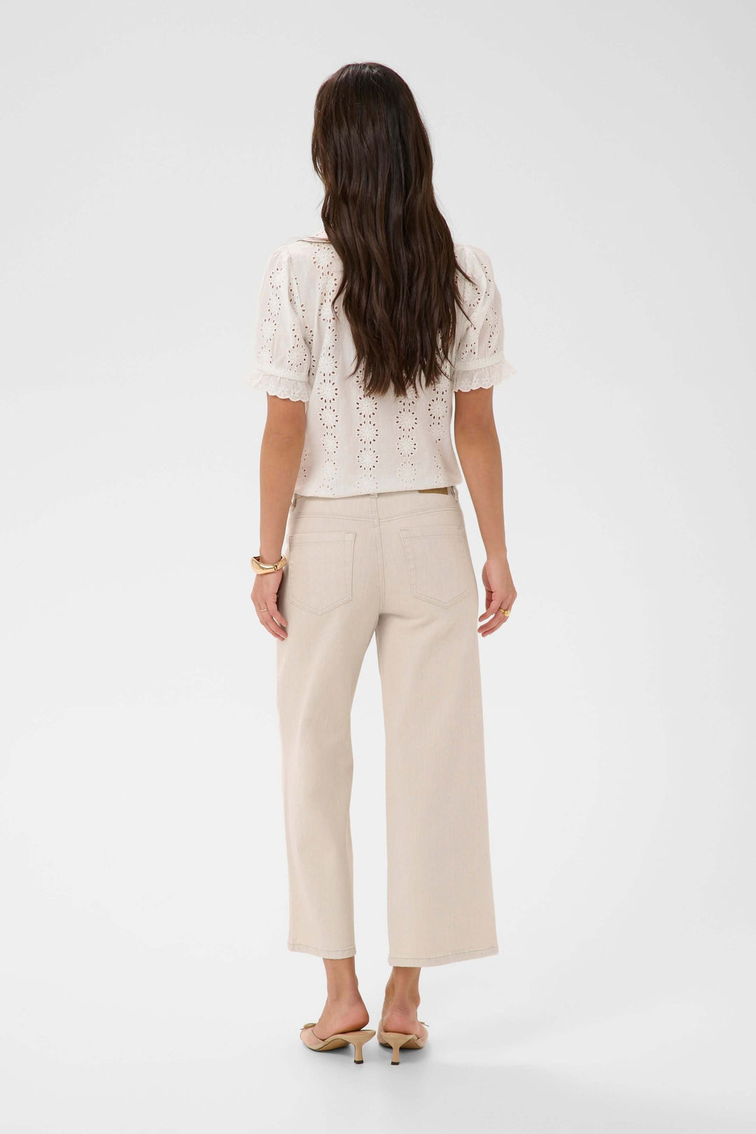 Femme portant Jeans Brook beige coupe droite de dos, avec un haut blanc dentelle, idéal pour un style polyvalent quotidien.