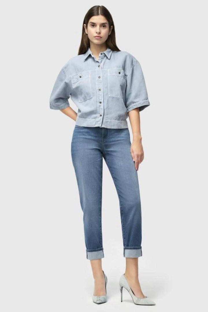 Femme portant un jeans léger avec revers, silhouette féminine, style classique et contemporain.