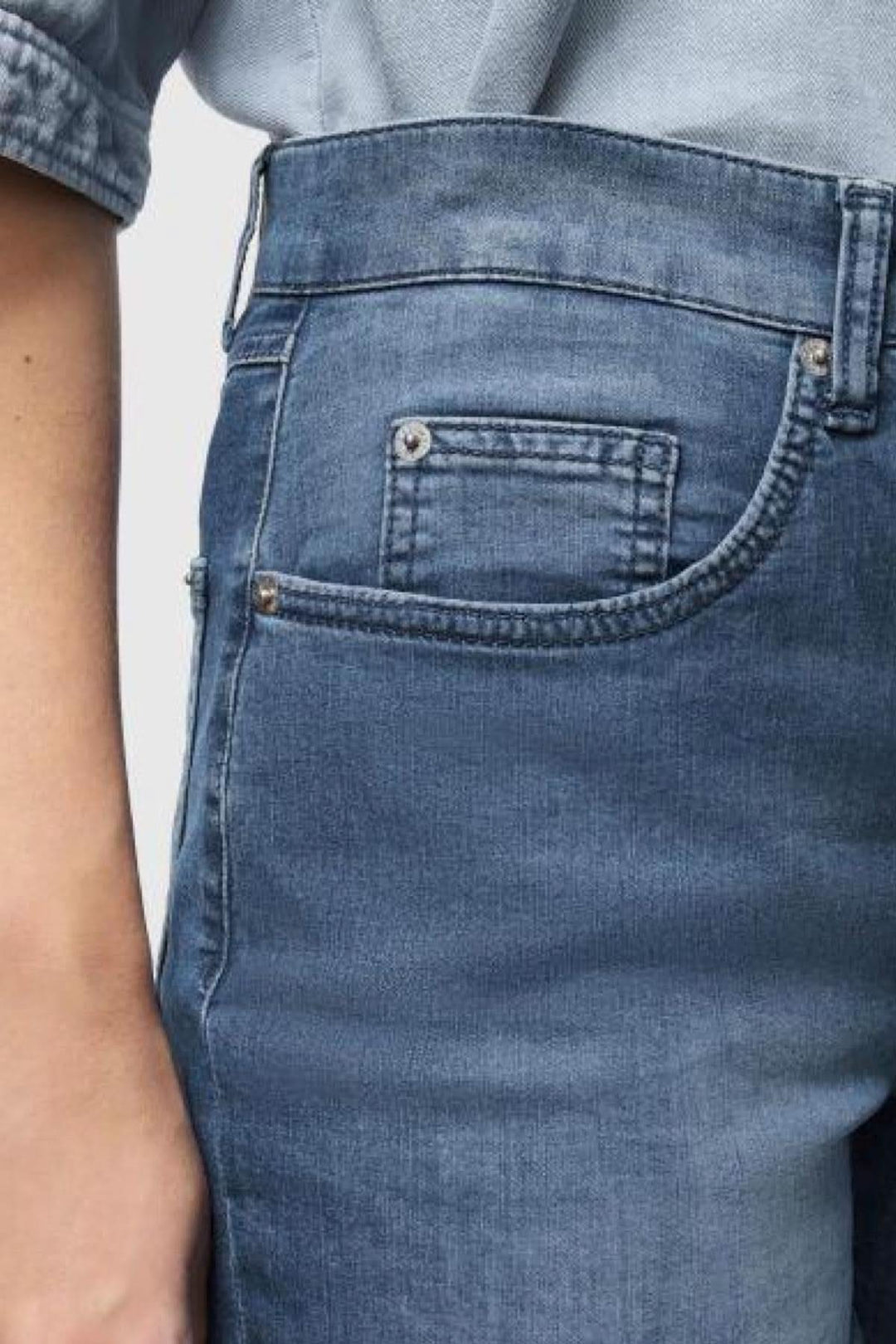 Détail du jeans Carol en denim léger avec une jambe droite et revers, offrant élégance et confort.