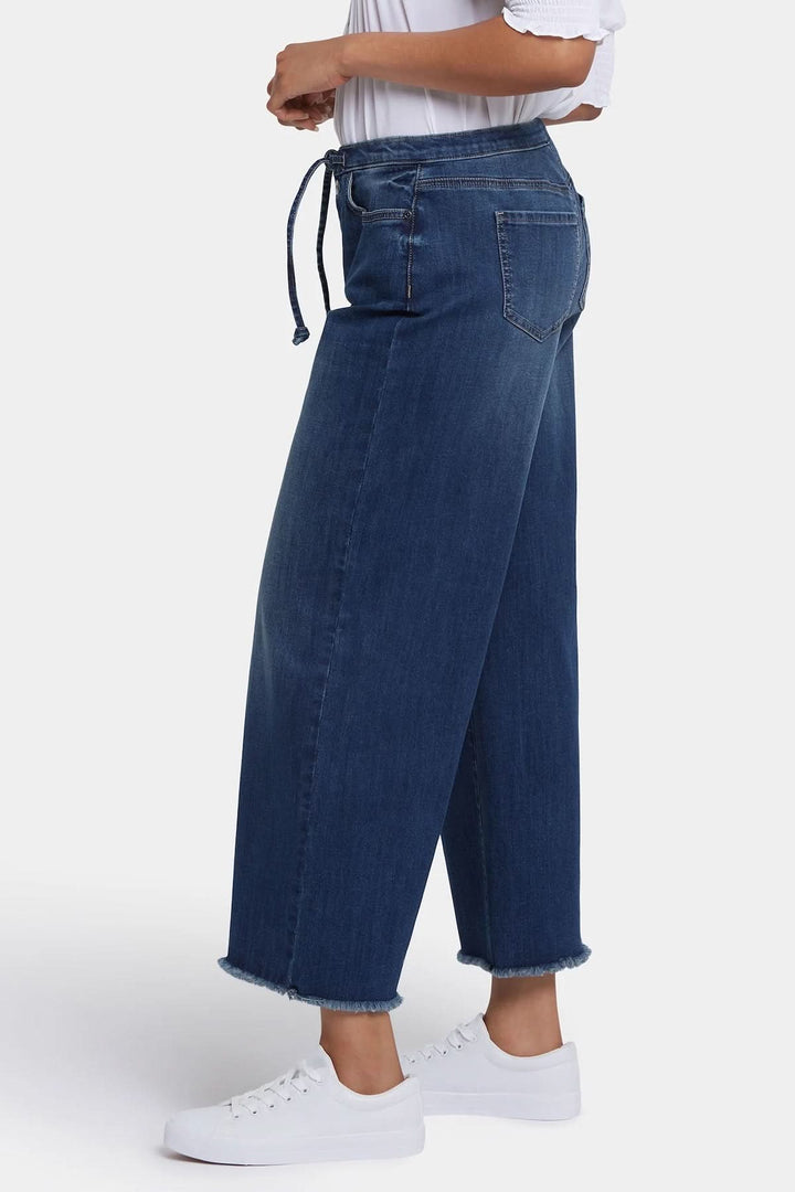 Jeans Cindi à jambe large avec taille haute et cordon ajustable pour un look moderne et décontracté.