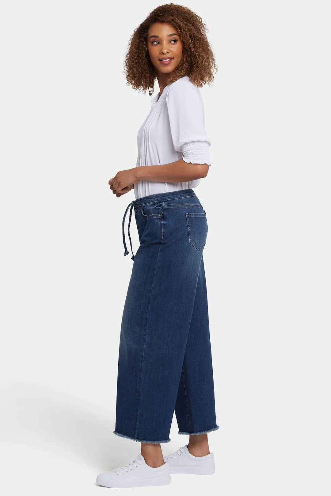 Femme portant des jeans larges Cindi avec taille haute et cordon ajustable, décontractée et moderne.
