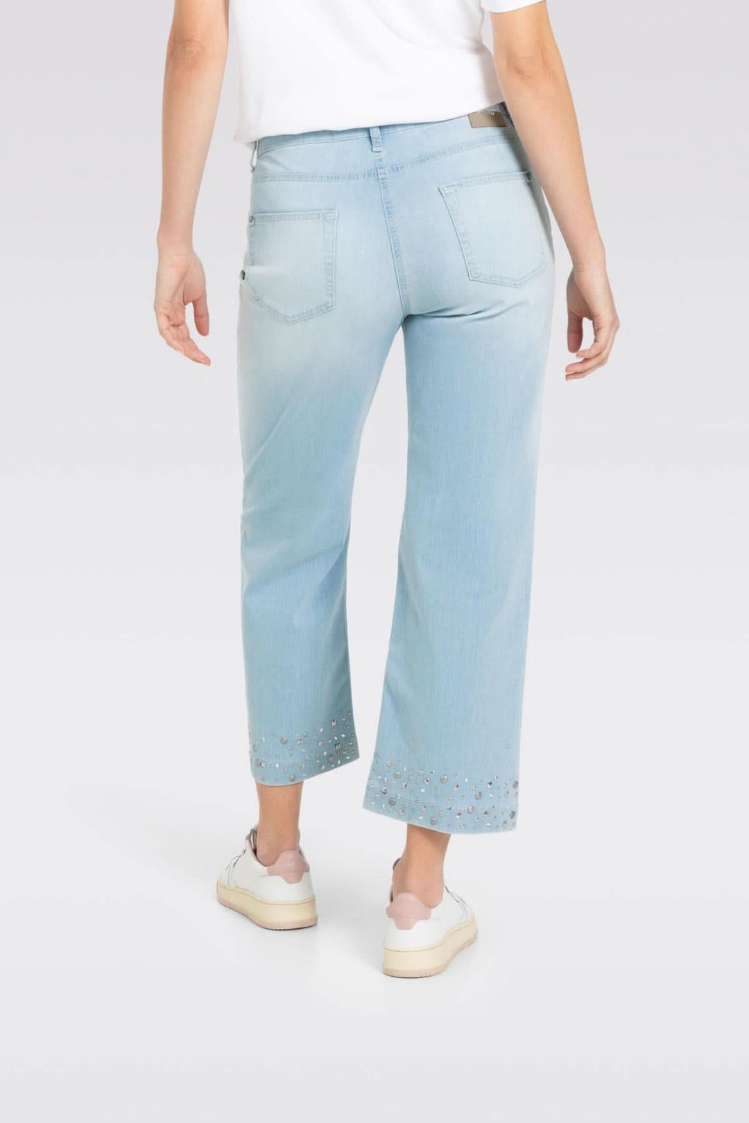 Jean culotte à coupe large avec studs brillants, porté avec un t-shirt et des baskets, vue arrière.