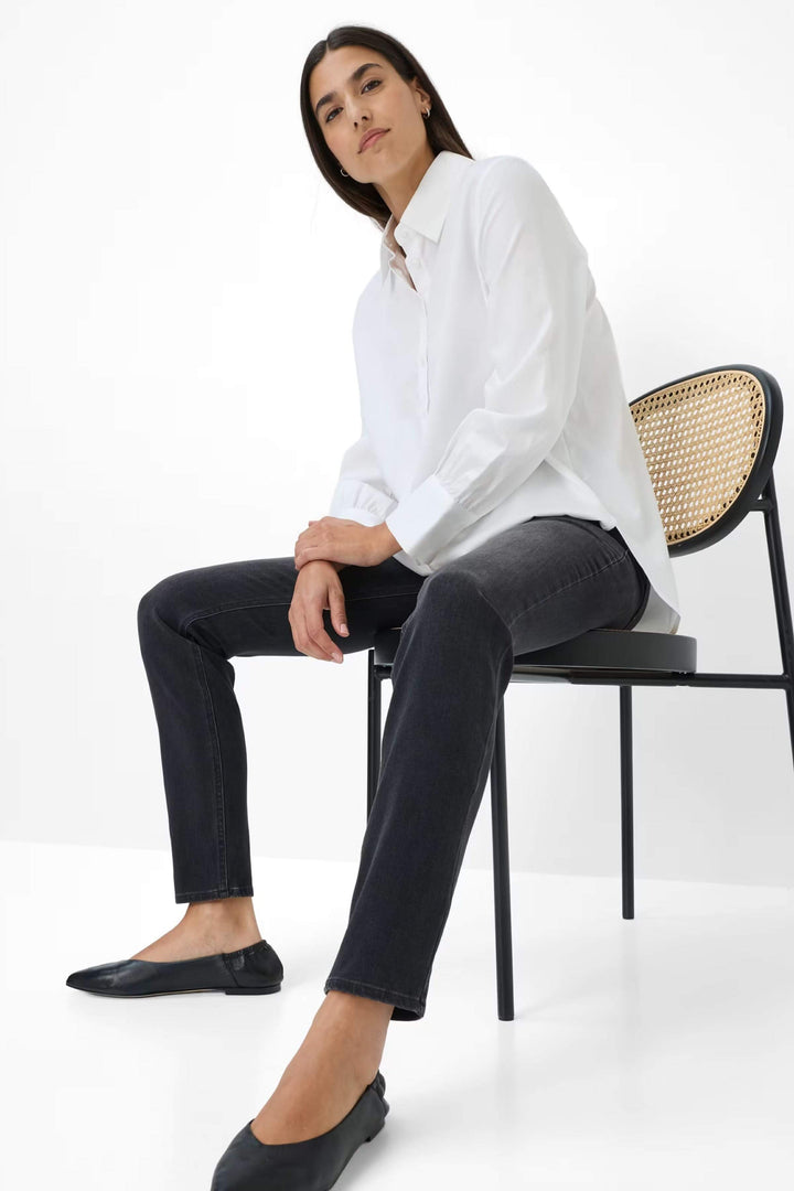 Femme portant Jeans Shakira coupe ajustée à taille mi-haute avec chemisier, confort et élégance pour look polyvalent.