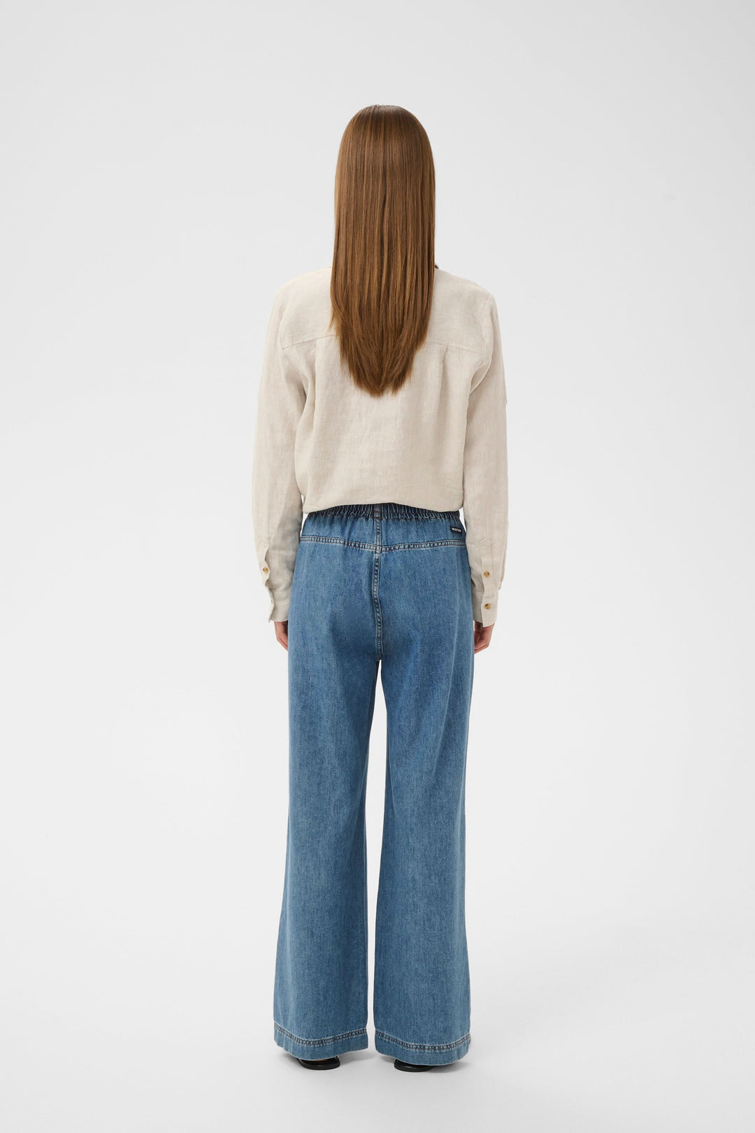 Vue arrière du Jeans Sophina taille élastique jambe large avec poches latérales et couture soignée. Tissu denim souple, look moderne.