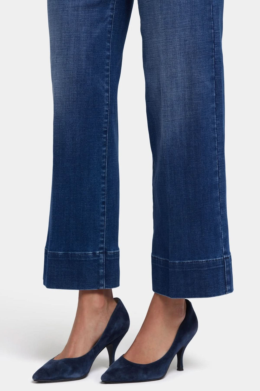 Jeans Teresa de NYDJ en denim bleu avec jambe large et ourlet de 3 pouces, associés à des talons élégants.