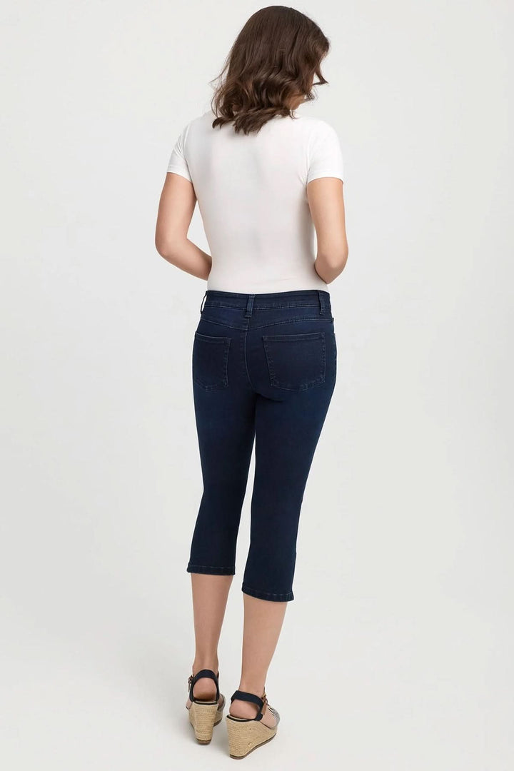 Femme portant des jeans capri ajustés de couleur bleu foncé, vue de dos.
