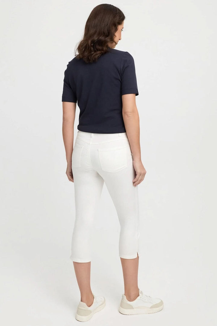 Femme de dos portant un t-shirt noir et un pantalon capri blanc, idéal pour un look estival décontracté.