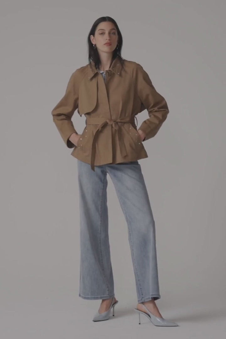 Femme portant un jeans à jambe large taille haute avec veste marron.