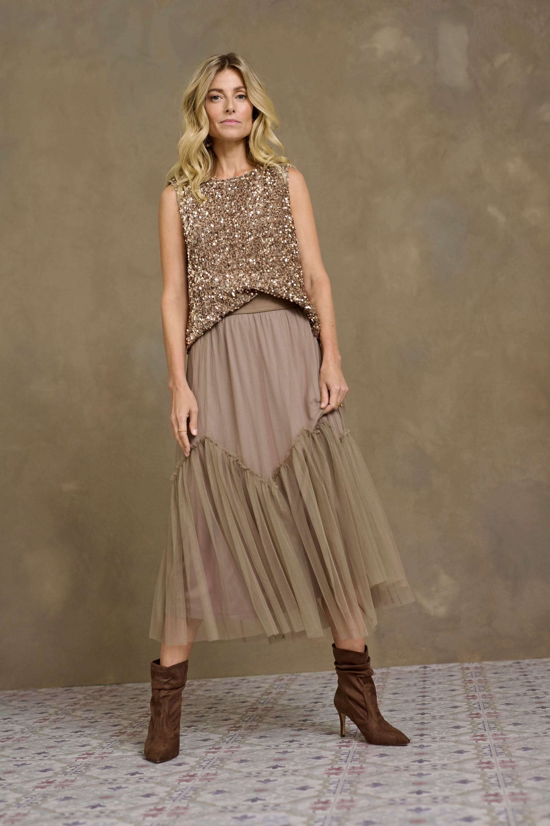 Modèle en jupe midi en tulle vaporeux et top pailleté, affichant une allure romantique.