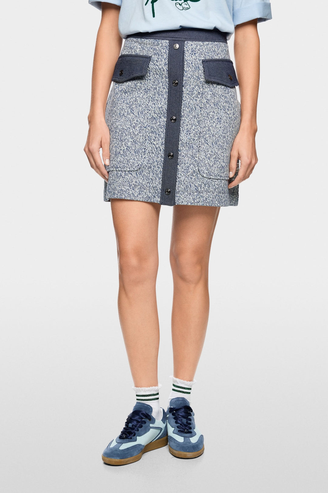 Jupe courte en viscose extensible avec fermeture boutonnée et poches à rabat, idéale pour un look moderne et utilitaire.