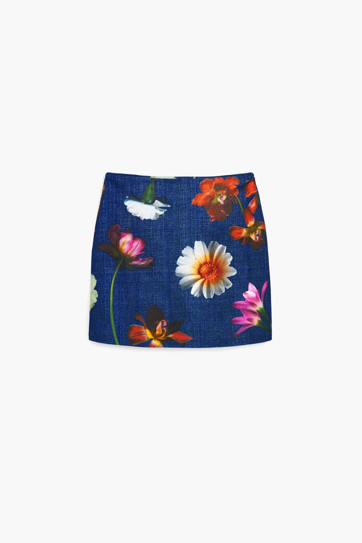 Jupe courte à fleurs sur fond bleu, avec broderie délicate et des imprimés romantiques.