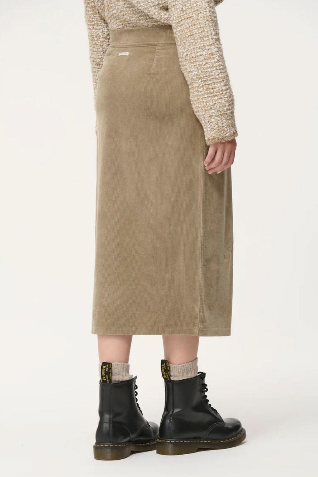 Jupe crayon taille haute en velours côtelé, vue arrière, portée avec des bottines noires.