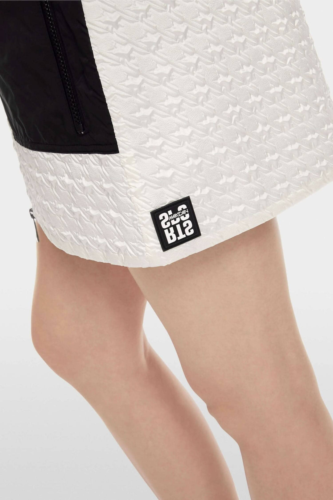 Mini-jupe matelassée en pied-de-poule avec poches zippées et fermeture éclair à double sens.