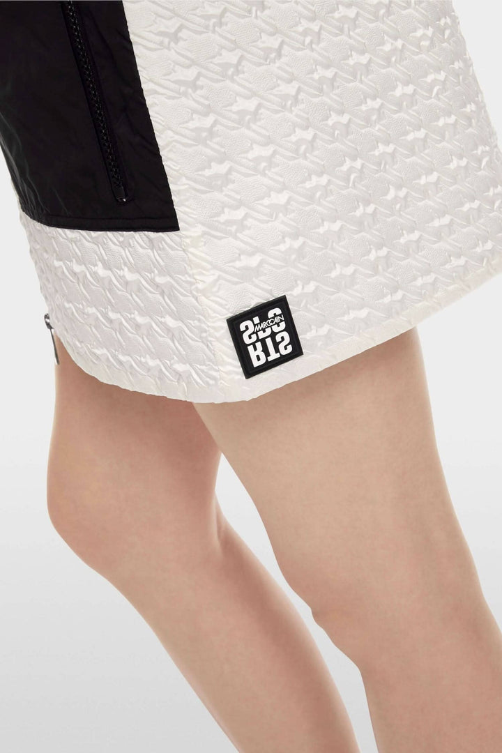 Mini-jupe matelassée en pied-de-poule avec poches zippées et fermeture éclair à double sens.