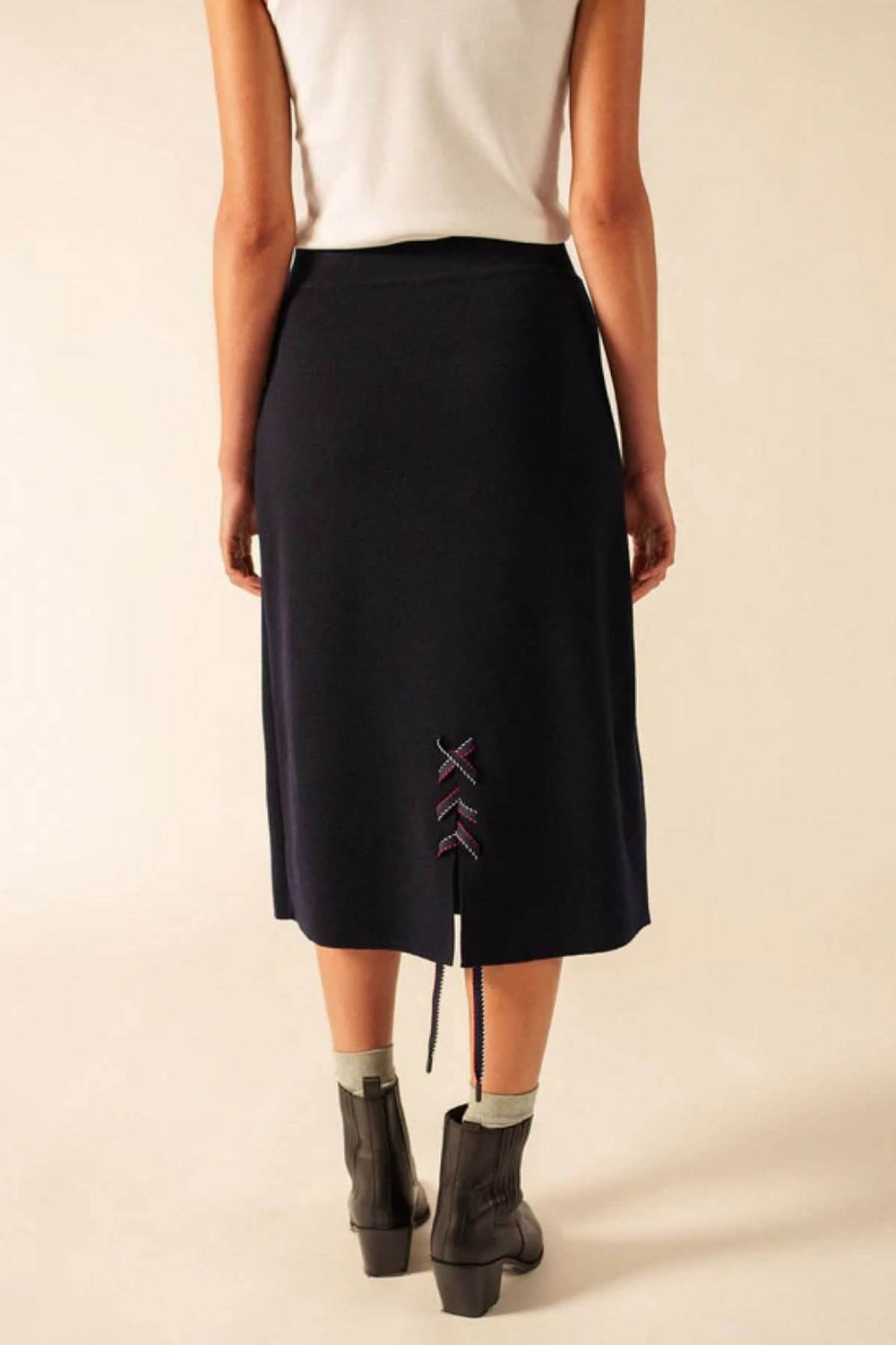 Vue arrière de la jupe midi en laine avec détail de laçage, texture douce, et coupe droite légèrement évasée. Taille élastique et confortable.