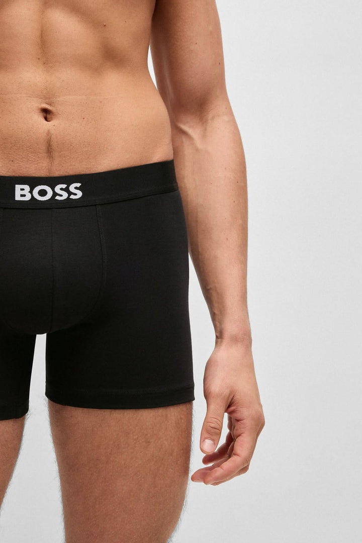 Homme portant des boxers noirs à ceinture avec logo BOSS pour un confort élégant et moderne.