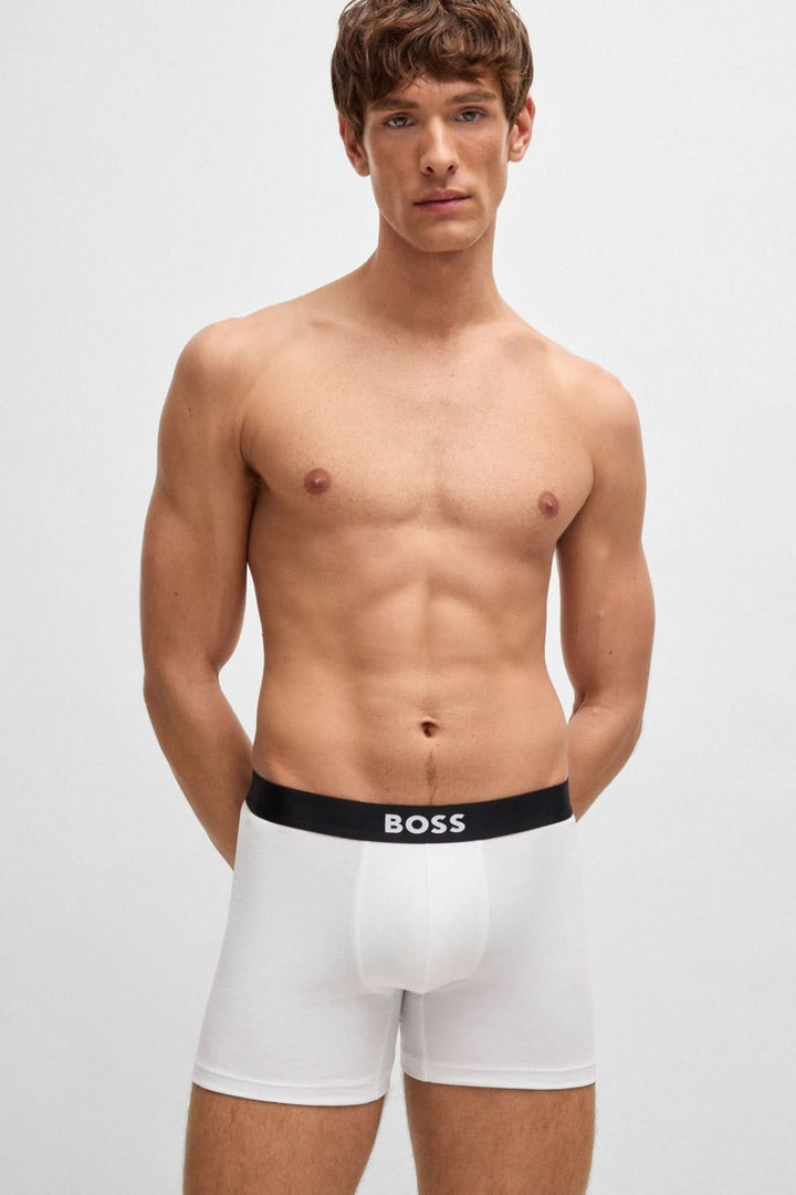 Homme portant un boxer blanc avec ceinture à logo BOSS, mettant en avant confort et élégance.