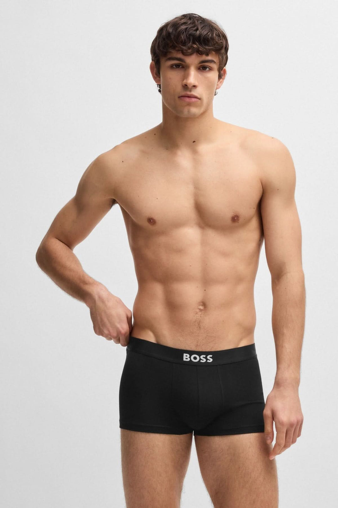 Homme portant un boxer court noir BOSS avec ceinture logo, mettant en avant confort et style moderne.