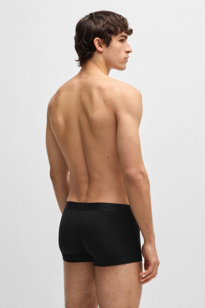 Homme portant un boxer noir, vue de dos, mettant en avant la coupe courte et le confort.