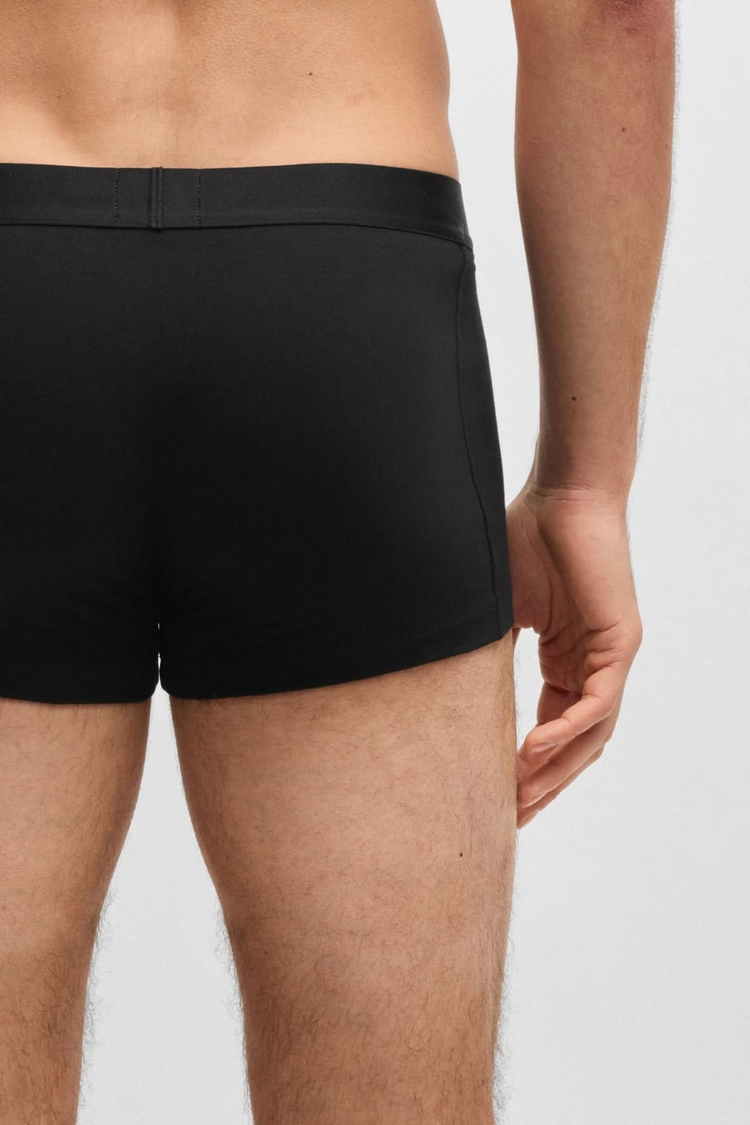 Arrière d'un homme portant des boxers courts noirs BOSS, soulignant le confort et l'élégance.