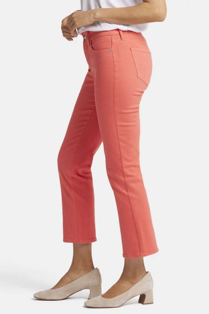 Pantalon Marilyn en rose, coupe classique droite, longueur jusqu'à la cheville, porté avec des escarpins beige.
