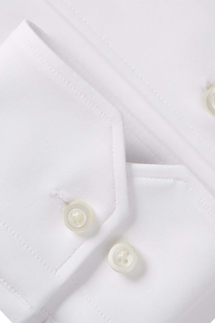 Détail d'une chemise habillée en coton blanc, avec col structuré et boutons ton sur ton.