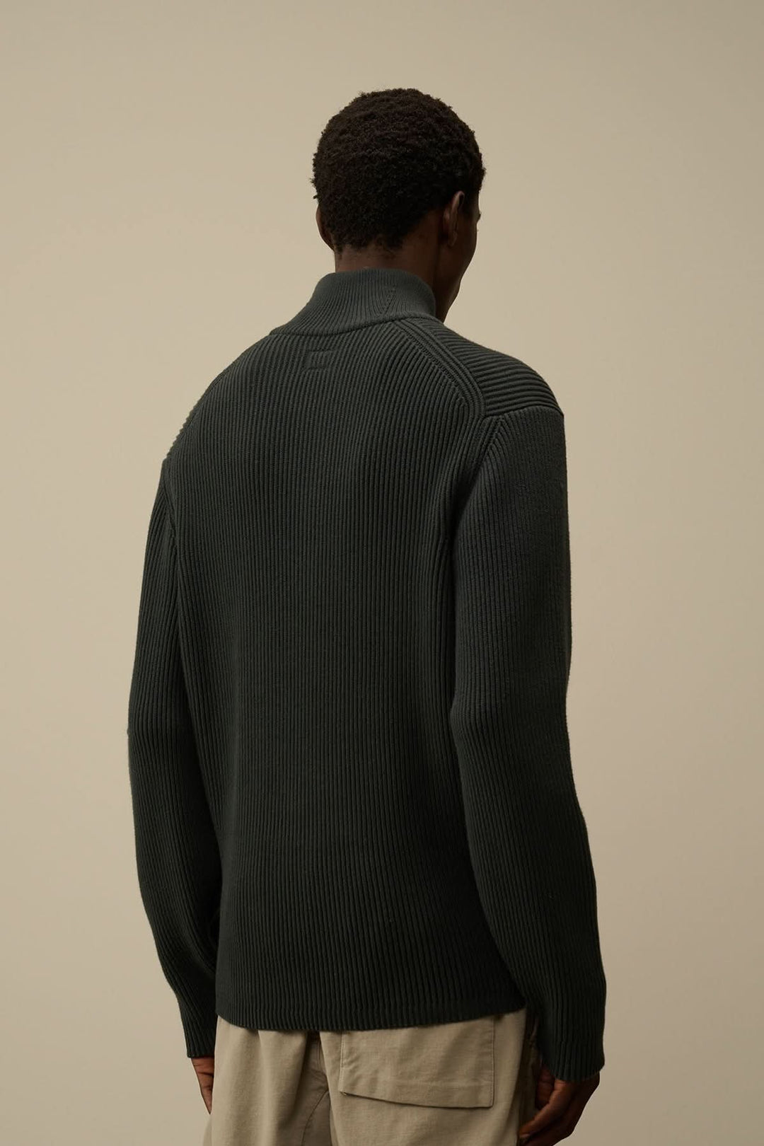 Homme portant un tricot demi-zip côtelé en Full Rib, vue arrière sur fond neutre.
