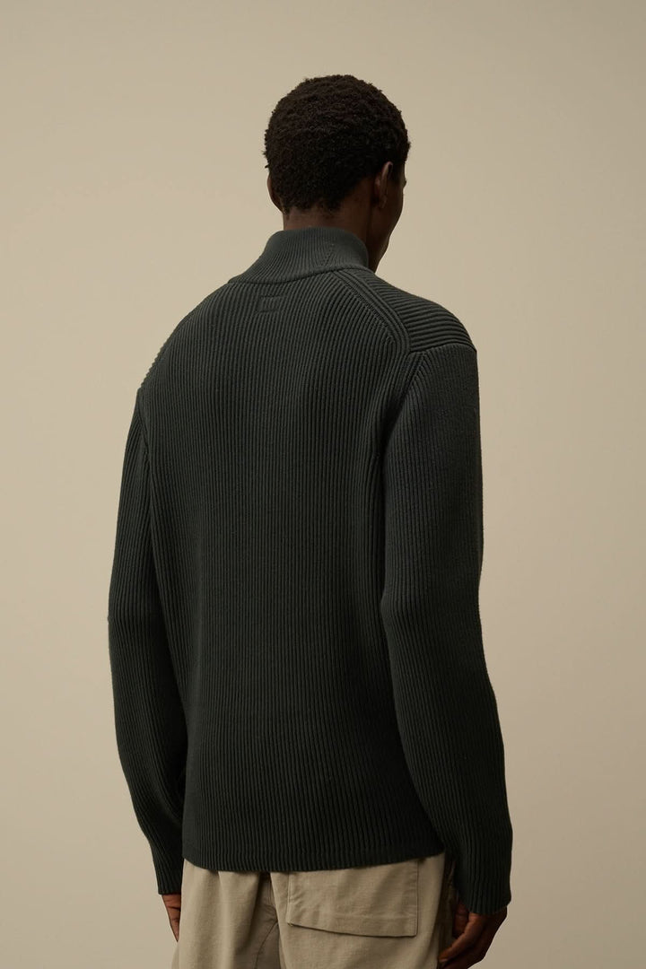 Homme portant un tricot demi-zip côtelé en Full Rib, vue arrière sur fond neutre.