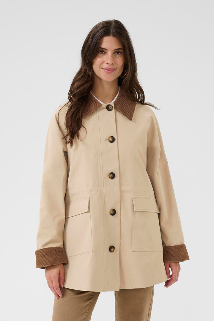 Manteau Jaxy avec col et revers en velours côtelé, coupe ample, grandes poches et boutons apparents, idéal pour la mi-saison.